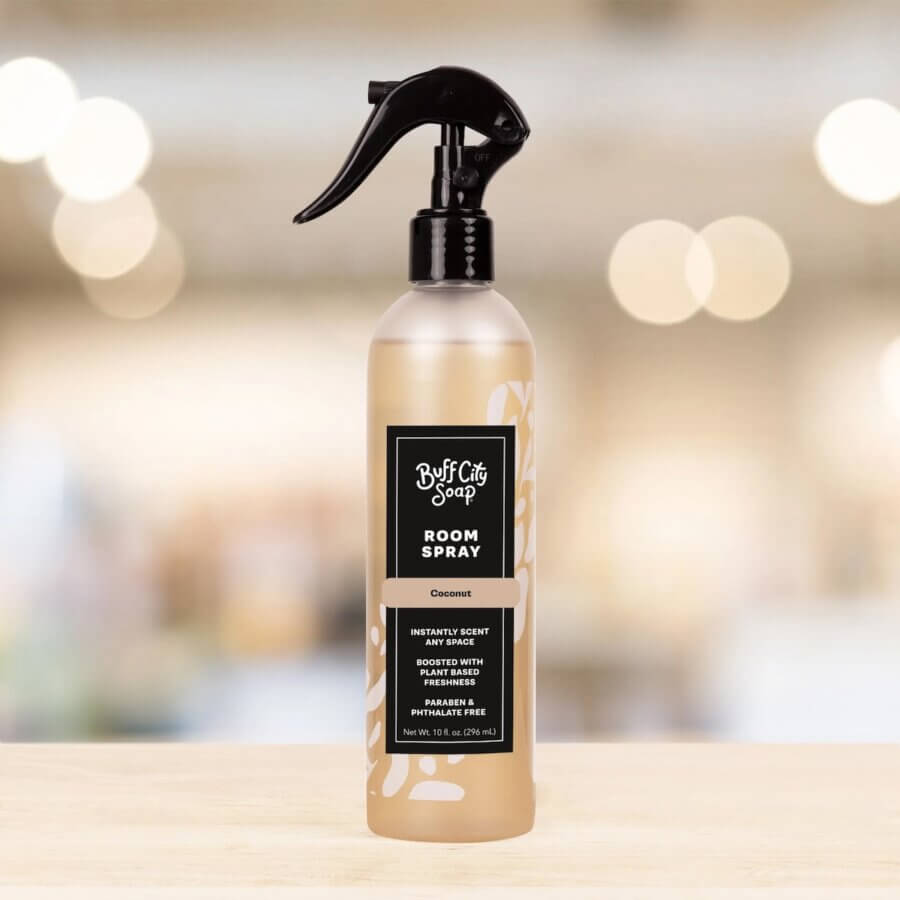 19 Fresh FINDS Around BHAM: Closet Refreshers, Entertaining Picks & More - 16 A bottle of Buff City Soap Room Spray in coconut scent with a black spray nozzle, featured as one of Birmingham FINDS April picks, displayed on a wooden surface with a blurred background.