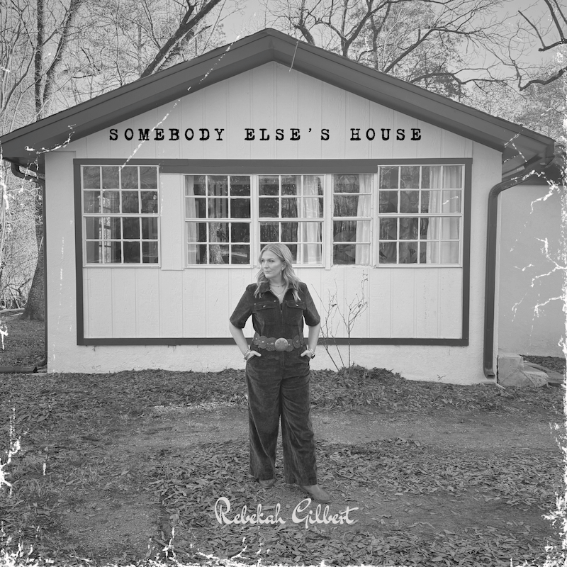 A woman stands in front of a house with large windows; text above reads "Somebody Else's House," and Americana artist Rebekah Gilbert is written at the bottom. The image has a vintage, worn effect, evoking timeless charm.