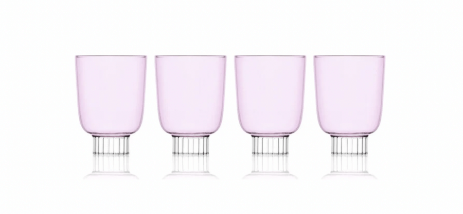 12 Colored Glass Accessories We Love: Cake Stands, Candlesticks & More - 7 Four transparent pink glasses with small, textured bases are lined up against a plain white background, adding a touch of spring charm to any setting. These colored glasses are sure to be a standout addition to your wish list.