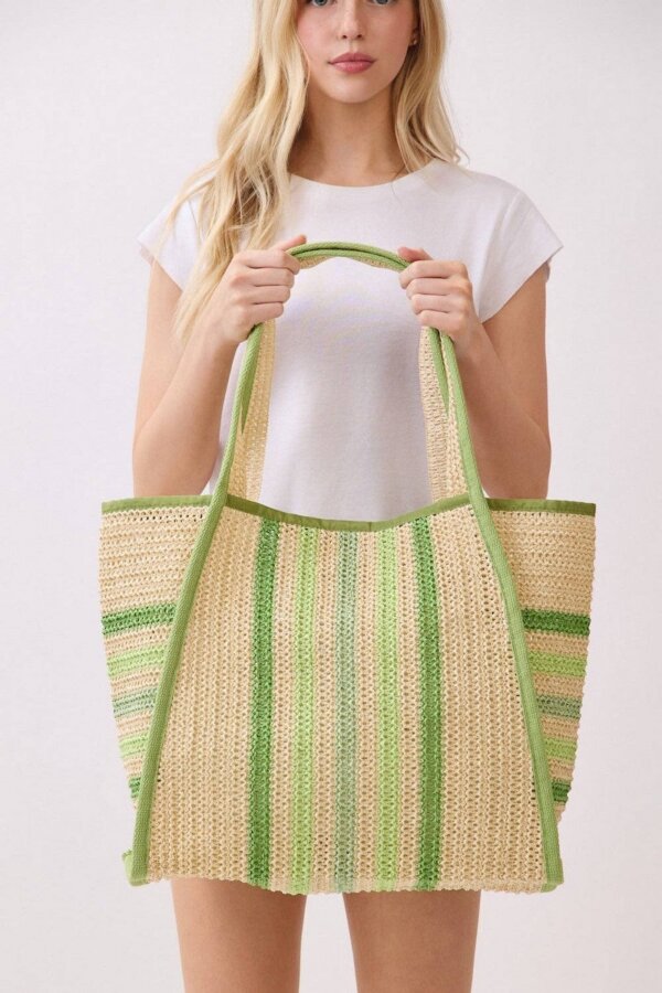 15 Memphis FINDS at Local Shops: Spring Dresses, Home Decor & More! - 8 A woman in a white t-shirt holds a large straw tote bag with green and beige vertical stripesβone of the standout Memphis FINDS this April.