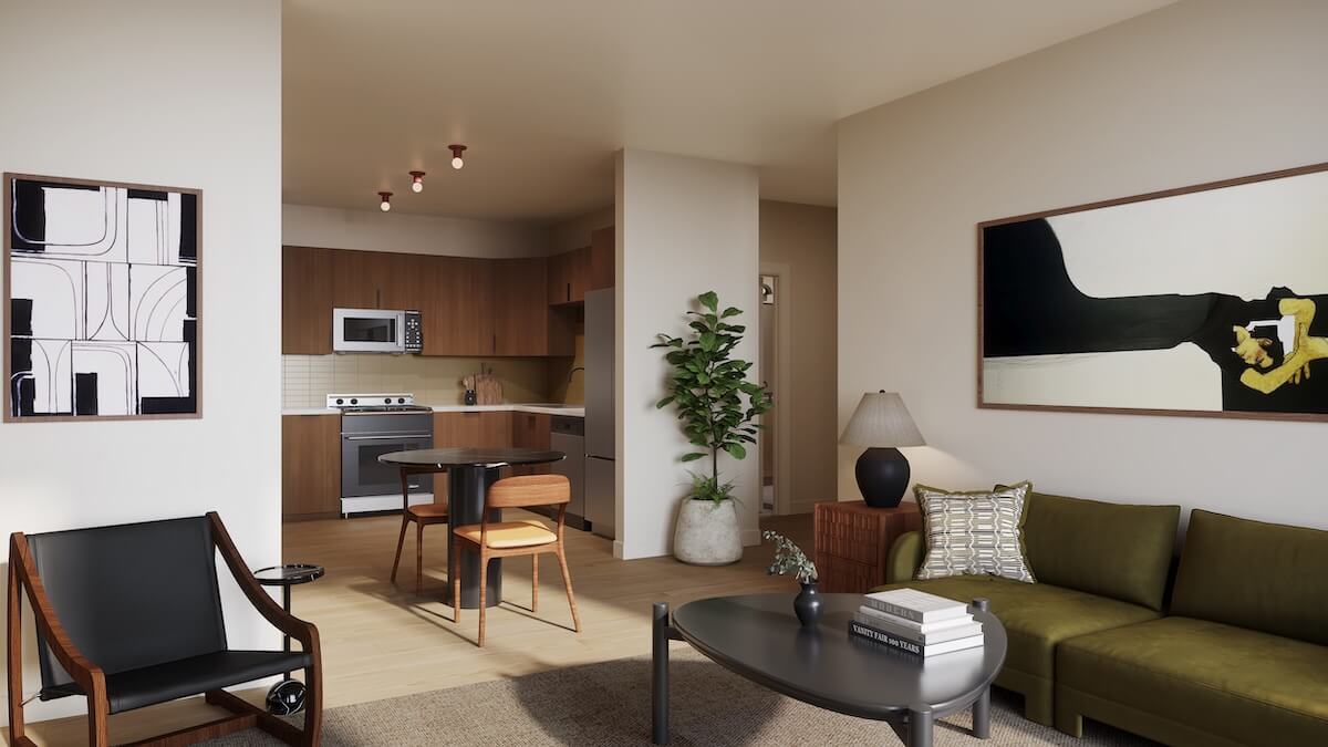 A modern apartment living room with a green sofa, abstract artwork, and a small dining area beside a kitchen featuring wood cabinets and stainless steel appliances—perfect for those seeking homes for sale in East Nashville.