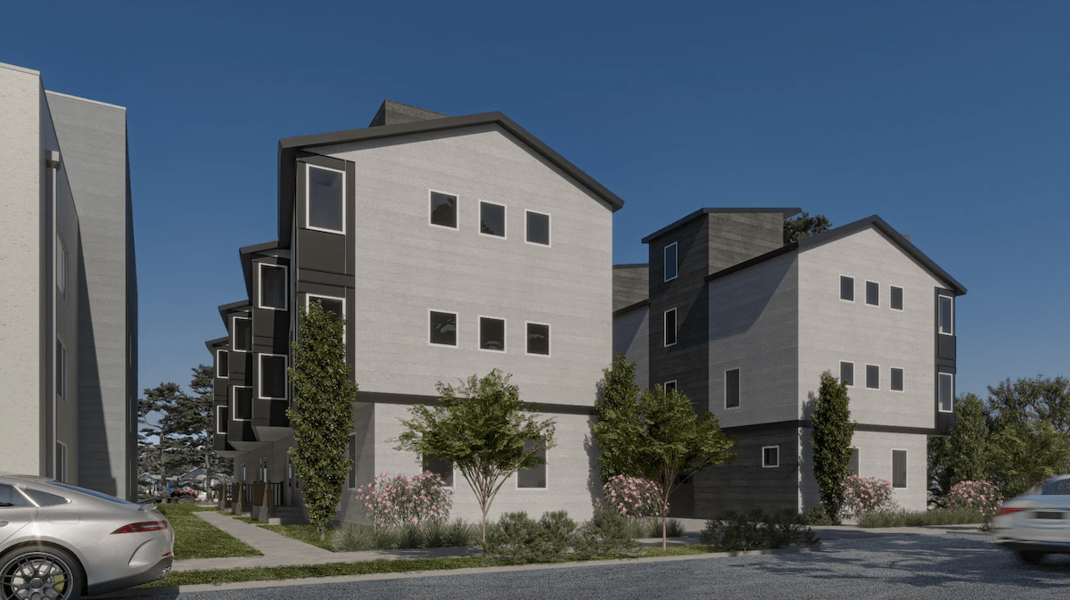 Modern three-story homes with multiple windows, surrounded by small trees and shrubs, on a clear day with parked cars nearby—perfect for those seeking new developments in East Nashville.