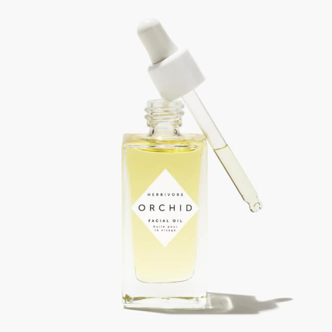The 5 Best-Smelling Skincare Products I Can't Live Without - 3 A glass bottle of Herbivore Orchid facial oil, known for its best-smelling skincare formula, filled with light yellow oil and topped with a dropper, set against a white background.