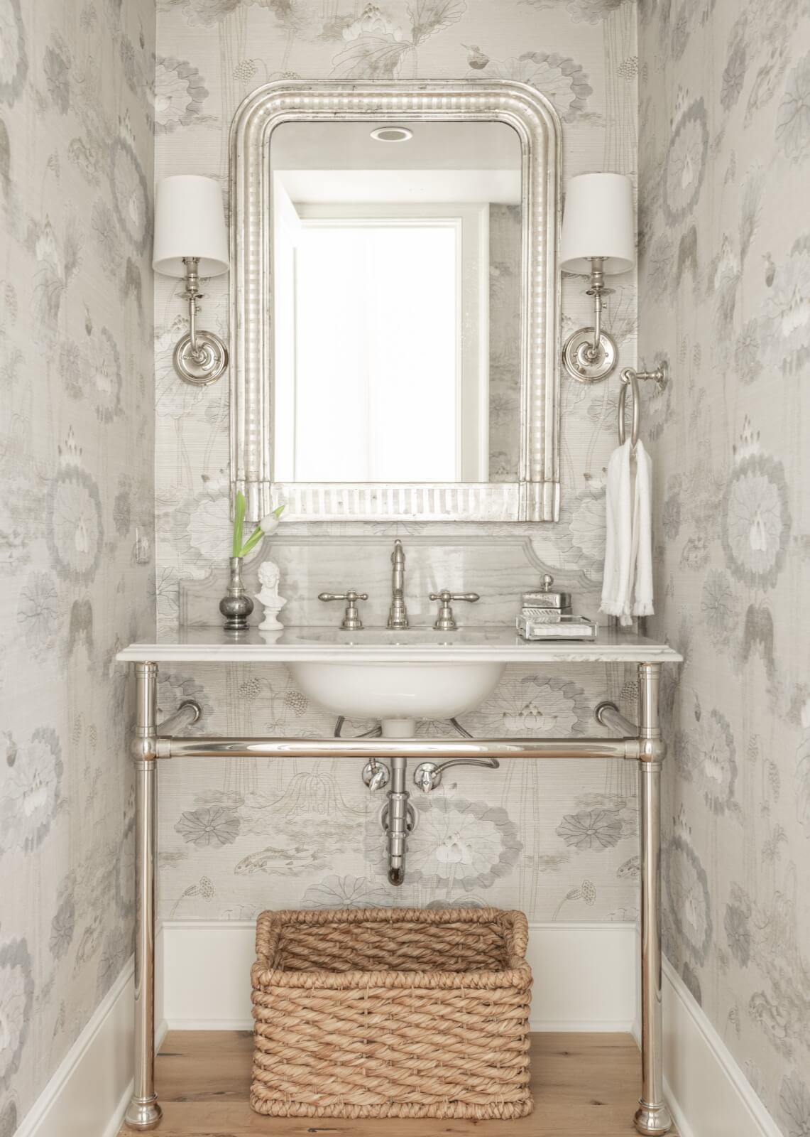 A powder room featuring an ornate mirror and patterned wallcoverings.