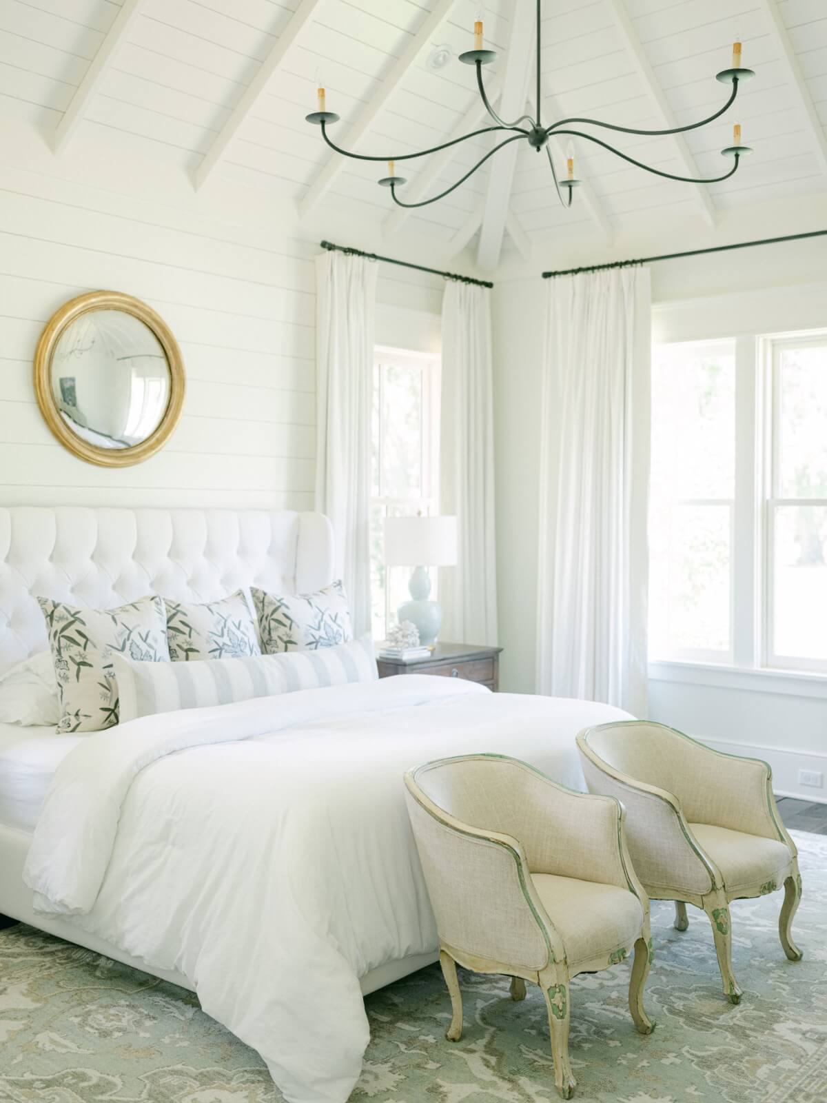 A white bedroom with vaulted ceilings.