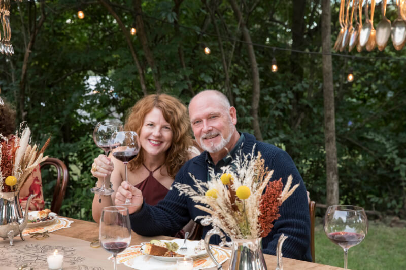 Angie and her husband, toasting with wine.