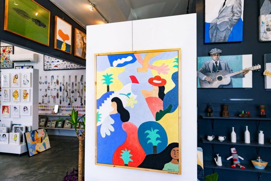 5 Reasons South Walton is Becoming the Premier Destination for Corporate Events and Meetings - 12 A colorful abstract painting on a white partition in an art gallery during an event in South Walton, surrounded by other paintings, prints, ceramics, and decorative objects.