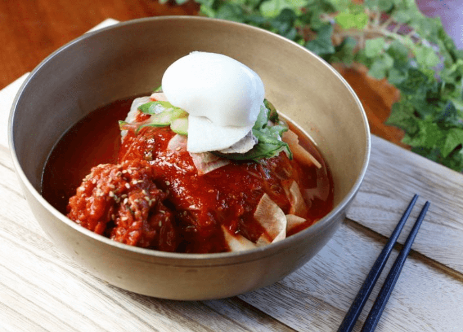 Georgia's 6 Best Girlfriends' Weekend Getaways - 14 Perfect for girlfriends’ getaways or women’s retreats, this bowl of Korean cold noodles is topped with sliced vegetables, kimchi, red chili sauce, and a poached egg, served on a wooden tray with chopsticks.