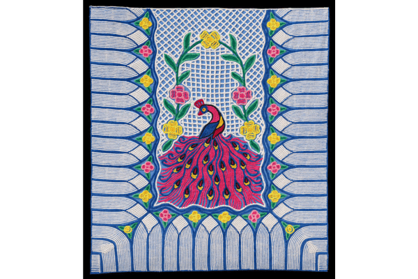 A colorful embroidered textile reminiscent of American quilts, featuring a stylized peacock in the center, surrounded by flowers and geometric blue patterns—a vivid tribute to the Fabric of a Nation.