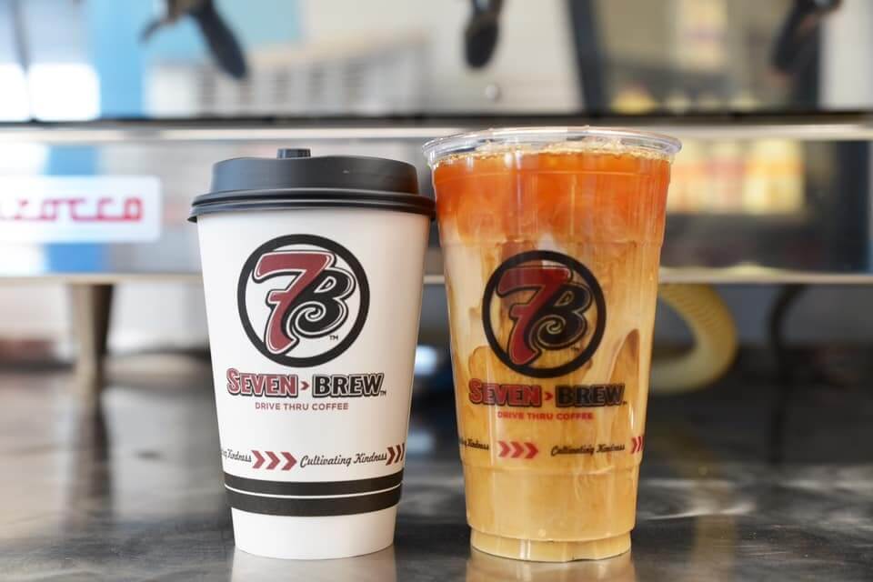 A hot coffee cup and an iced coffee cup with Seven Brew branding are placed side by side on a counter at a new Memphis restaurant.
