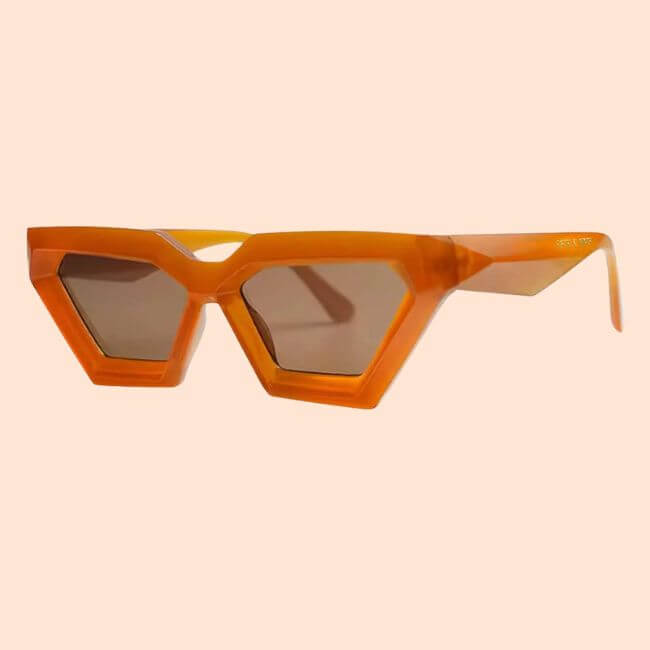 20 Spring FINDS for Mother’s Day & Beyond: Style, Beauty & Home Must-Haves - 2 Orange geometric sunglasses with thick angular frames and dark lenses, displayed on a light beige background—a trendy accessory often spotted in stylish Nashville shops.