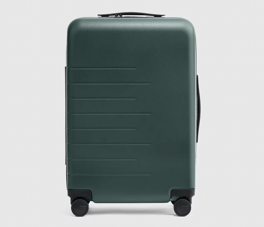 A dark green hard-shell travel luggage piece with four wheels and a black handle, shown standing upright against a plain light background.