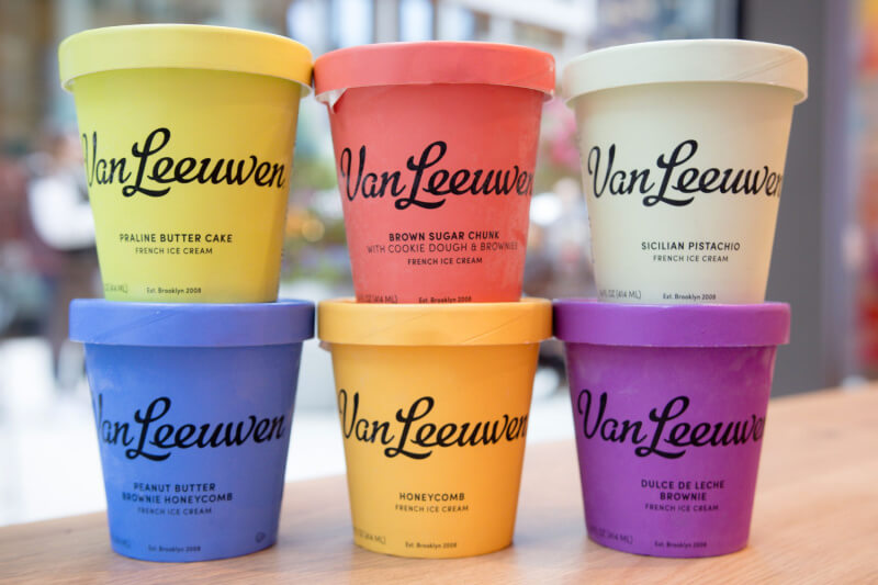 9 New Nashville Restaurants to Try This Month - 18 Six Van Leeuwen ice cream pints in various colors and flavors are arranged in two rows on a wooden surface, perfect for those exploring new restaurants or planning sweet treats at upcoming Nashville restaurants in May 2025.