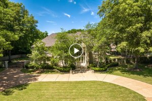 A large, two-story house on Forest Hill Ln in Germantown TN with a circular driveway, surrounded by trees and landscaped greenery on a sunny day.