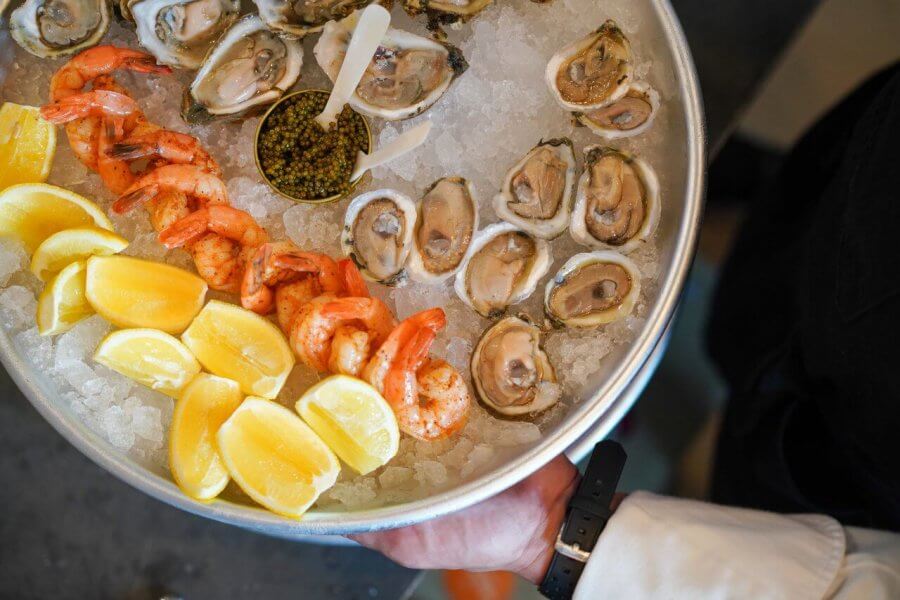 5 Reasons South Walton is Becoming the Premier Destination for Corporate Events and Meetings - 10 A platter with raw oysters, shrimp, lemon wedges, and a container of caviar arranged on crushed ice—perfect for your next event in South Walton.
