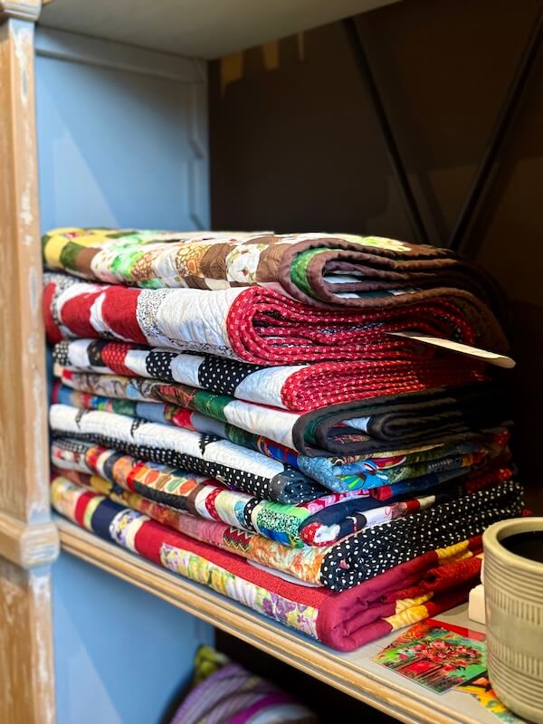 A stack of quilts on a shelf