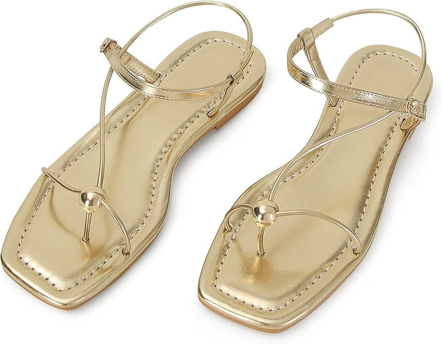 Pair of gold strappy sandals against a white backdrop.