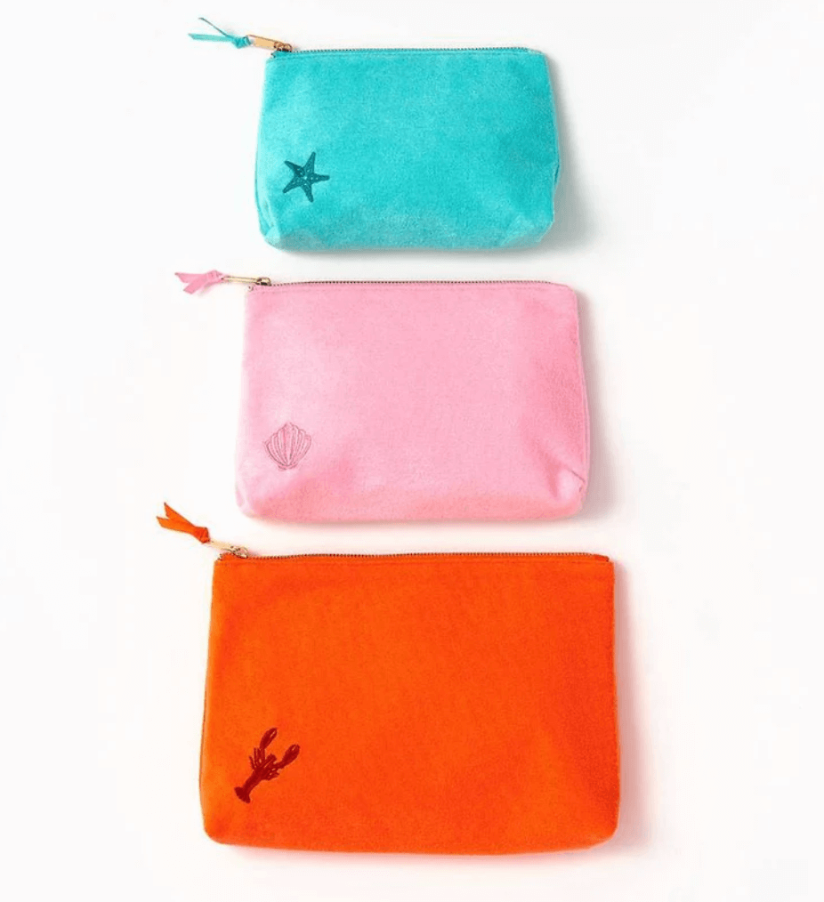 Discover June FINDS from Birmingham: three zippered pouches—teal with a star, pink with a shell, and orange with a lobster—arranged vertically on a white background.