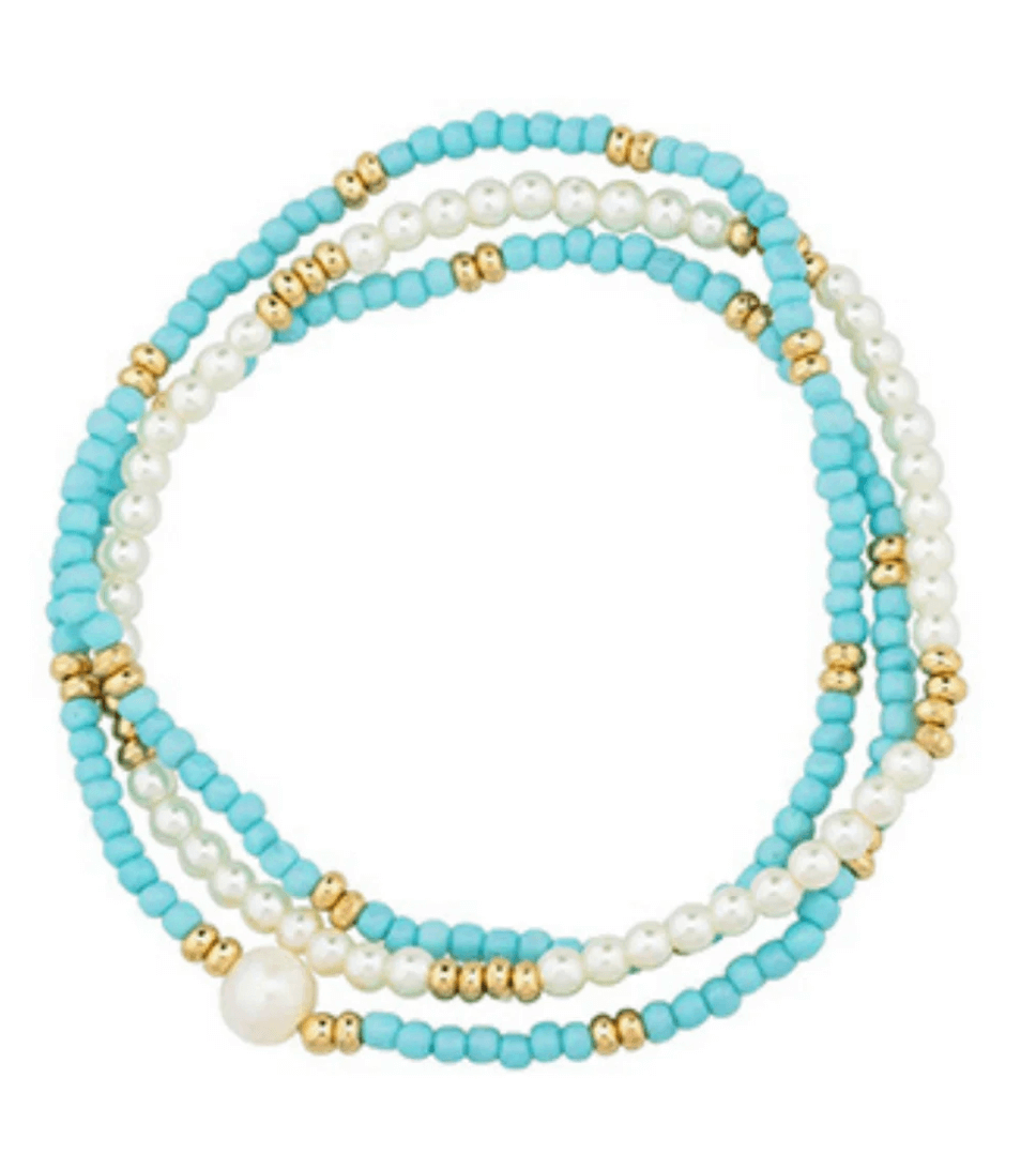 Stacked beaded bracelet featuring strands of turquoise, white, and gold beads, including one large white bead, arranged in a layered design—perfect for adding a touch of Birmingham charm to your June wardrobe.