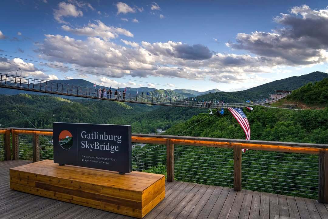 A suspension bridge spans across a lush, green mountain valley at the Gatlinburg SkyBridge, making it a perfect spot for weekend last-minute getaways.