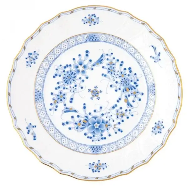 A round white porcelain plate with a scalloped edge, decorated with blue floral patterns and gold trim—a true Luxurious Memphis FINDS for July 2025.