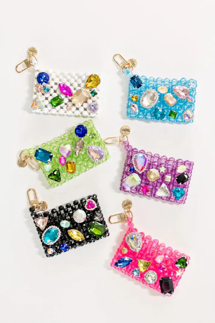 Six beaded card holders in vibrant Memphis-inspired colors, each adorned with assorted large, colorful gems, are arranged on a white background—perfect for summer 2025.