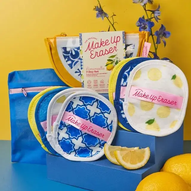 Reusable makeup remover pads in blue and yellow patterns are displayed with a zipped pouch, lemons, flowers, and MakeUp Eraser packaging—perfect for 2025 summer Memphis finds on your next Memphis shopping spree.
