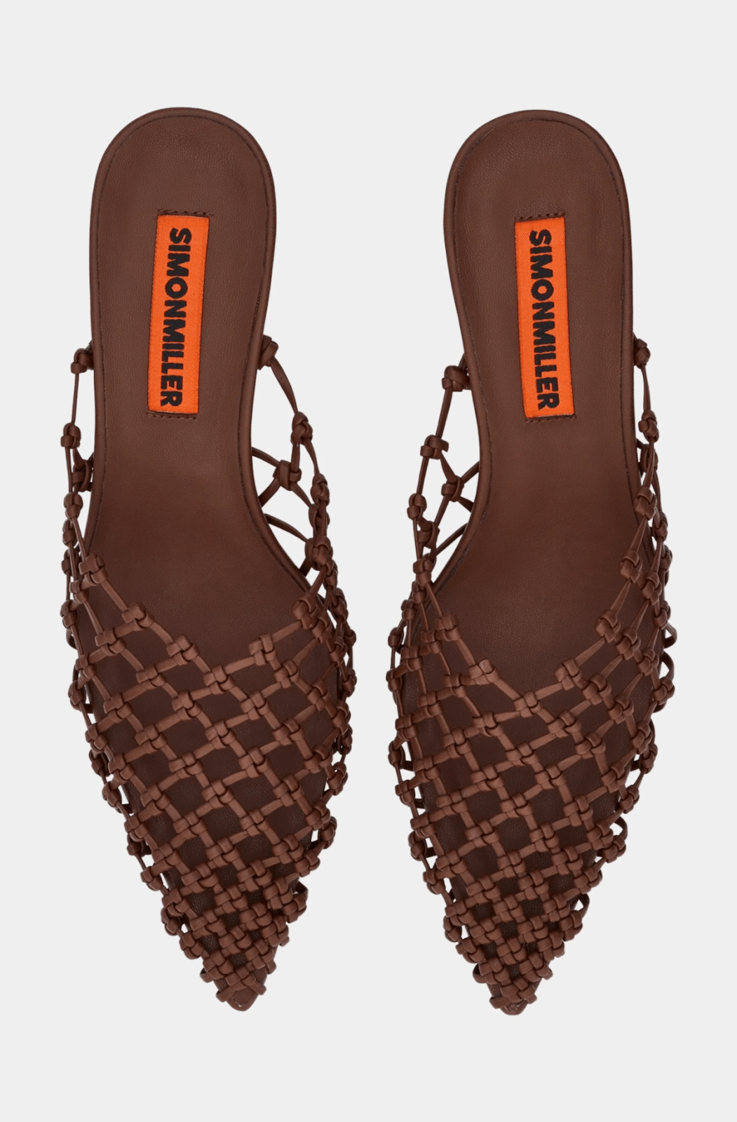 A pair of luxurious brown woven slip-on flats with pointed toes and orange SIMONMILLER labels on the insoles, perfect for strolling through Memphis in style this July 2025.