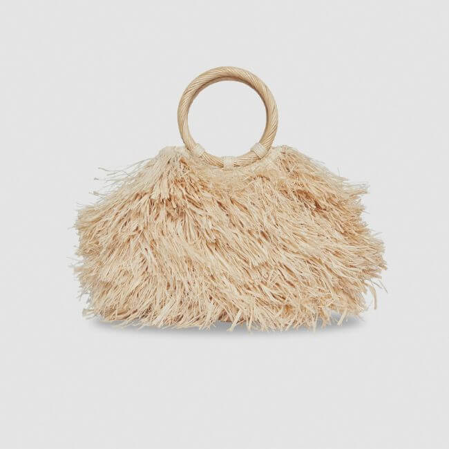 20 Nashville FINDS for June: Father's Day Gifts, Chic Accessories & More - 9 A handbag with round woven handles and a textured exterior made of straw-like fringes, perfect for shopping Nashville boutiques, displayed against a plain light background.