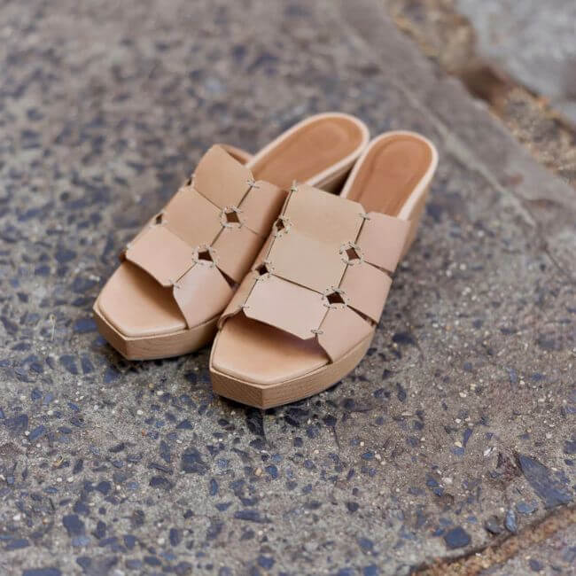 20 Nashville FINDS for June: Father's Day Gifts, Chic Accessories & More - 6 A pair of beige, open-toe slip-on sandals with a geometric cutout design, perfect for shopping Nashville’s trendy boutiques, placed on a textured concrete surface.