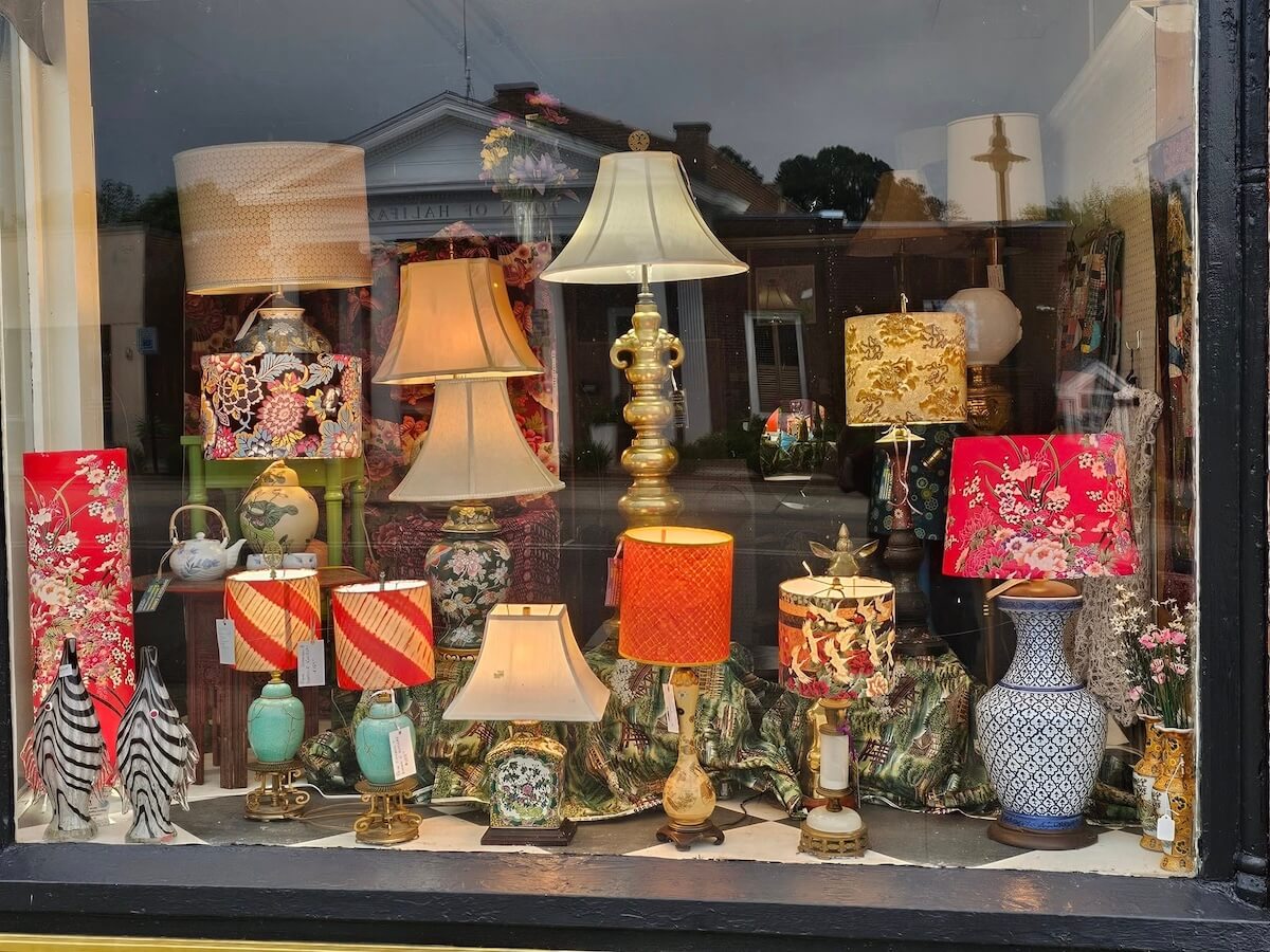 Display window featuring a variety of decorative table lamps in different shapes, sizes, and patterns—perfect accents to bring charm to weekend getaways in Virginia or cozy evenings at home.