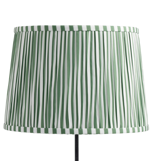 A lampshade with vertical green and white cabana stripes fabric pattern.