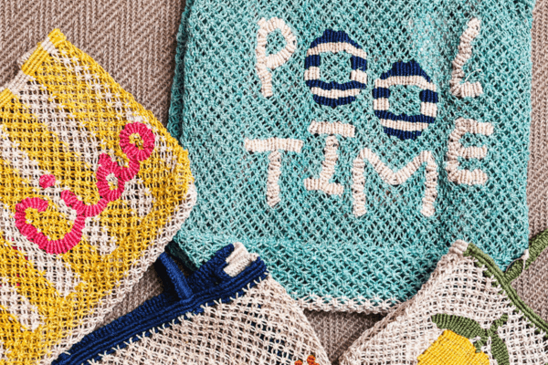 Several woven pouches in various colors and designs, including one blue pouch with "POOL TIME" stitched on it—perfect for Summer Sale finds.