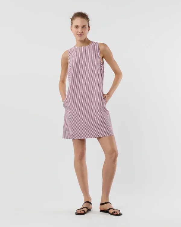 A woman stands against a plain background wearing a sleeveless, red and white vertically striped dress and black sandals—an effortlessly chic look from Memphis FINDS for August 2025.