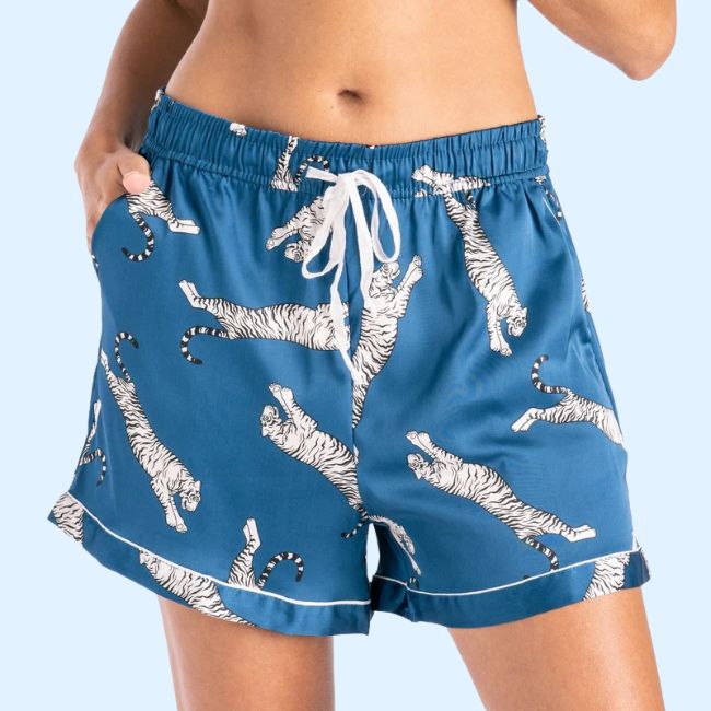 Person wearing blue shorts with a white tiger print pattern and white drawstring, standing with one hand in a pocket—a stylish Memphis FINDS look for August 2025.
