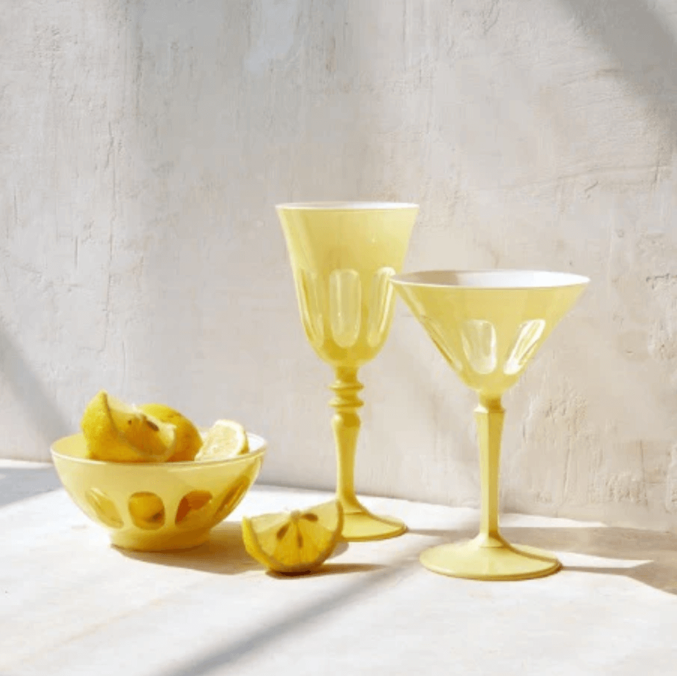 18 Nashville FINDS for Late Summer: Jewelry, Decor & More - 2 Yellow glass bowl with lemon wedges beside two yellow stemmed glasses, all set on a light surface in the soft natural light and shadows of a late summer day in Nashville.