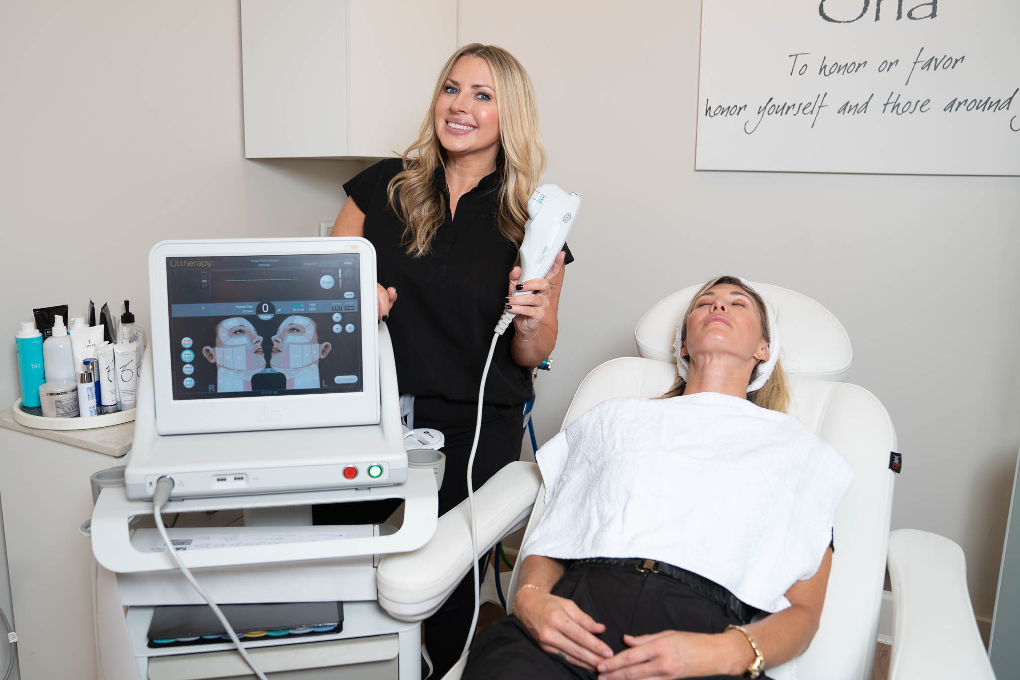 A practitioner prepares to use a cosmetic device on a woman lying on a treatment chair, with skincare products, a monitor nearby, and exclusive Nashville deals enhancing the experience.