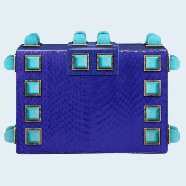18 Nashville Luxe Loves: Statement Jewelry, Custom Hats & Summer Showstoppers - 7 A rectangular, textured royal blue handbag with turquoise square studs and matching turquoise clasps—this is a statement piece set against a light background.