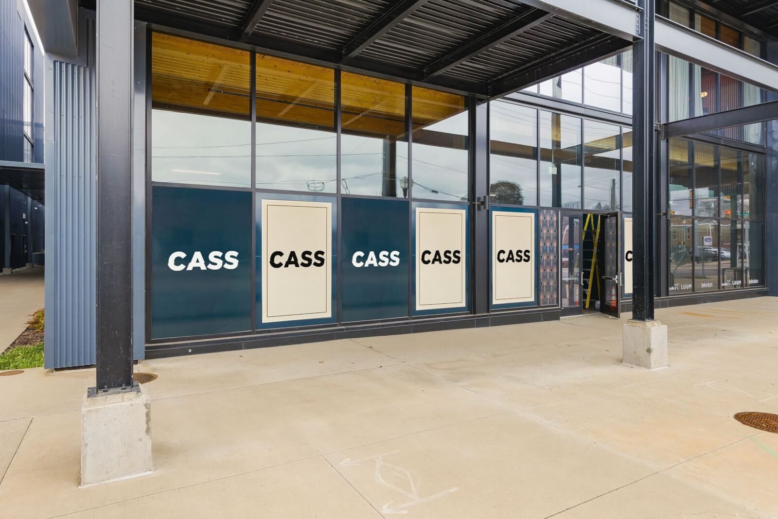 The exterior of a modern building with large windows and five panels displaying the word "CASS" in bold letters, perfect for highlighting Nashville Announcements or exclusive Nashville Deals.