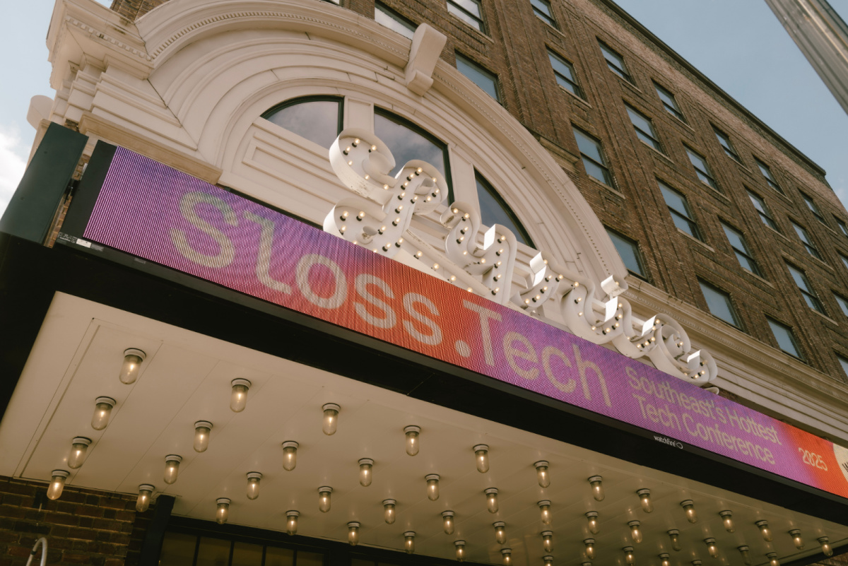 Marquee of a theater building displays a digital banner for Sloss Tech, the Southeast’s Hottest Tech Conference, with visible light bulbs underneath the awning.