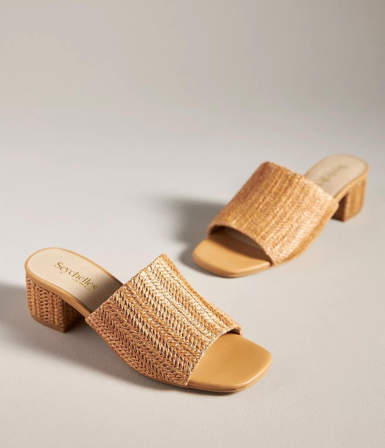 A pair of woven tan slide sandals with open toes and block heels, set on a neutral background—so stylish, you'll want one in every color.