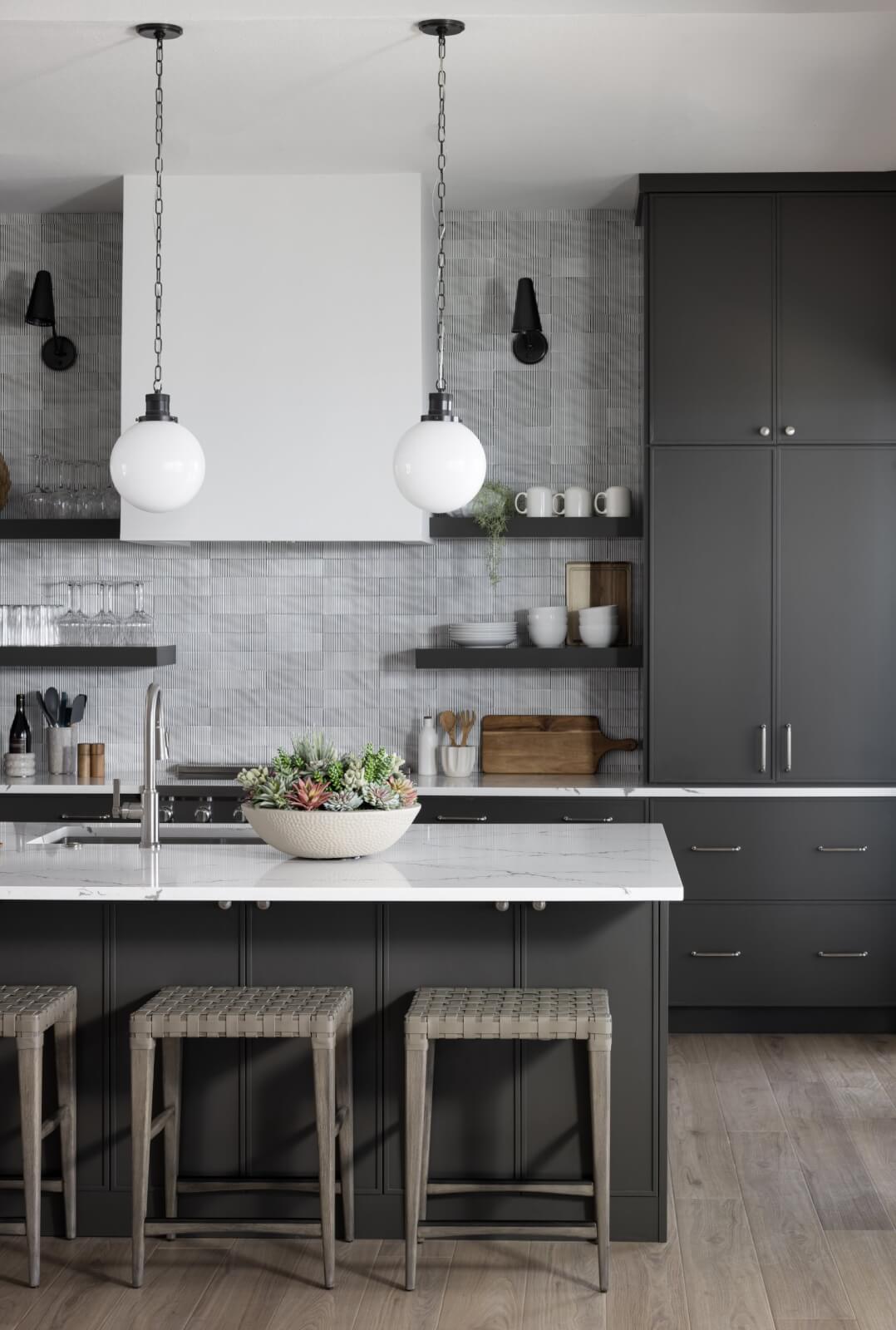 Look Inside This Effortlessly Chic Cape Haze Fishing Retreat - 5 A kitchen with charcoal cabinetry and pendant lighting.