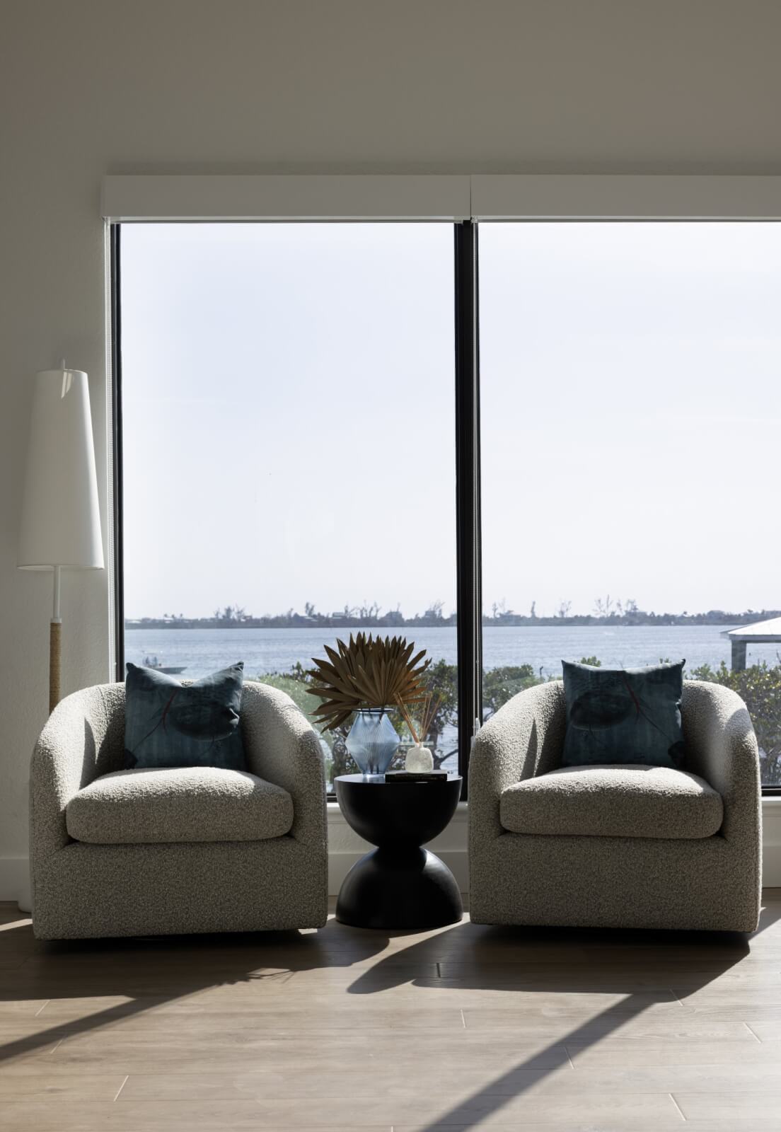 Look Inside This Effortlessly Chic Cape Haze Fishing Retreat - 14 Two chairs in front of a sliding door that features a view of the ocean.