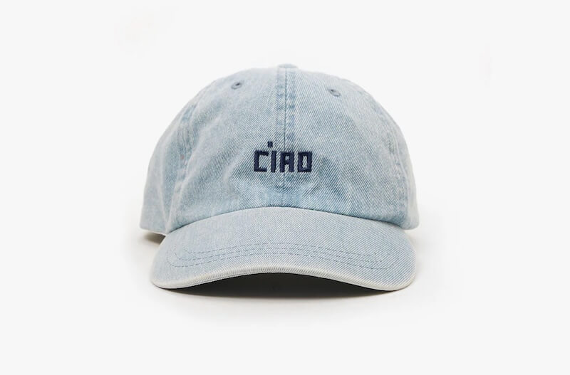 A light blue denim baseball cap with the word "Ciao" embroidered in dark blue on the front, photographed against a plain white background. Perfect for collecting—get one in every color.