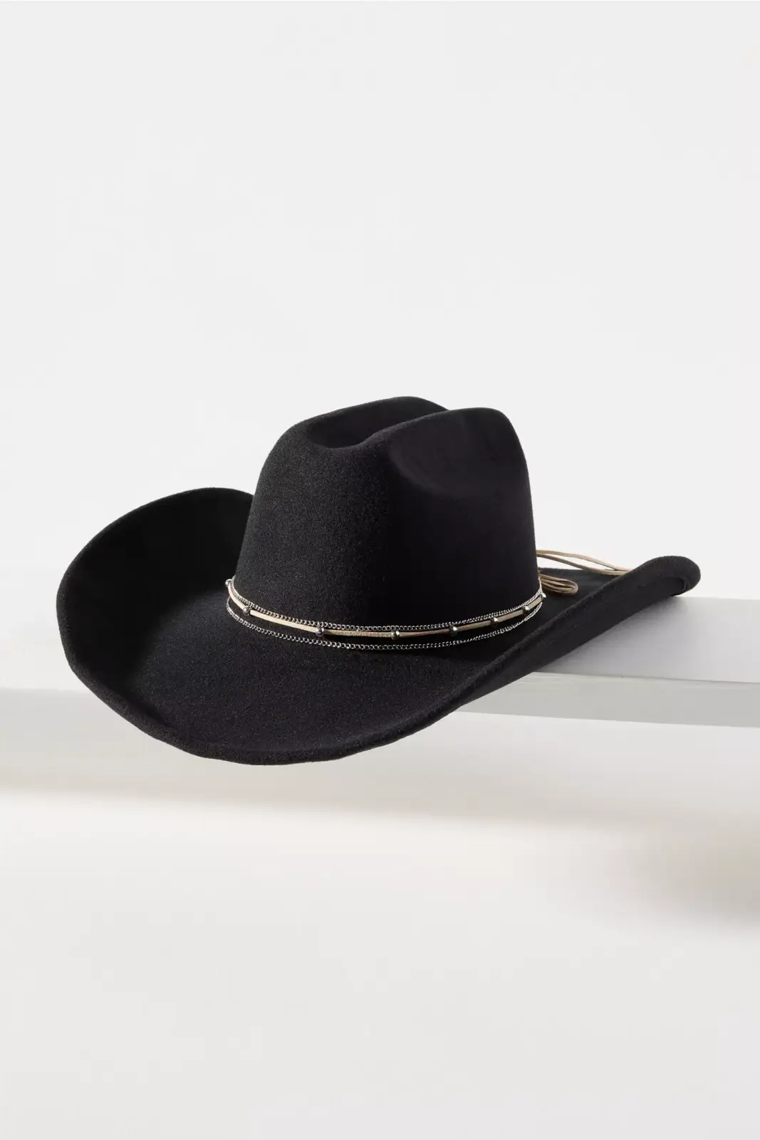 Fall 2025 Fashion: A Stylist's Lookbook of This Season's Trends - 68 A black cowboy hat with a decorative band rests on a white surface against a plain background, embodying the bold spirit of fall 2025 fashion.