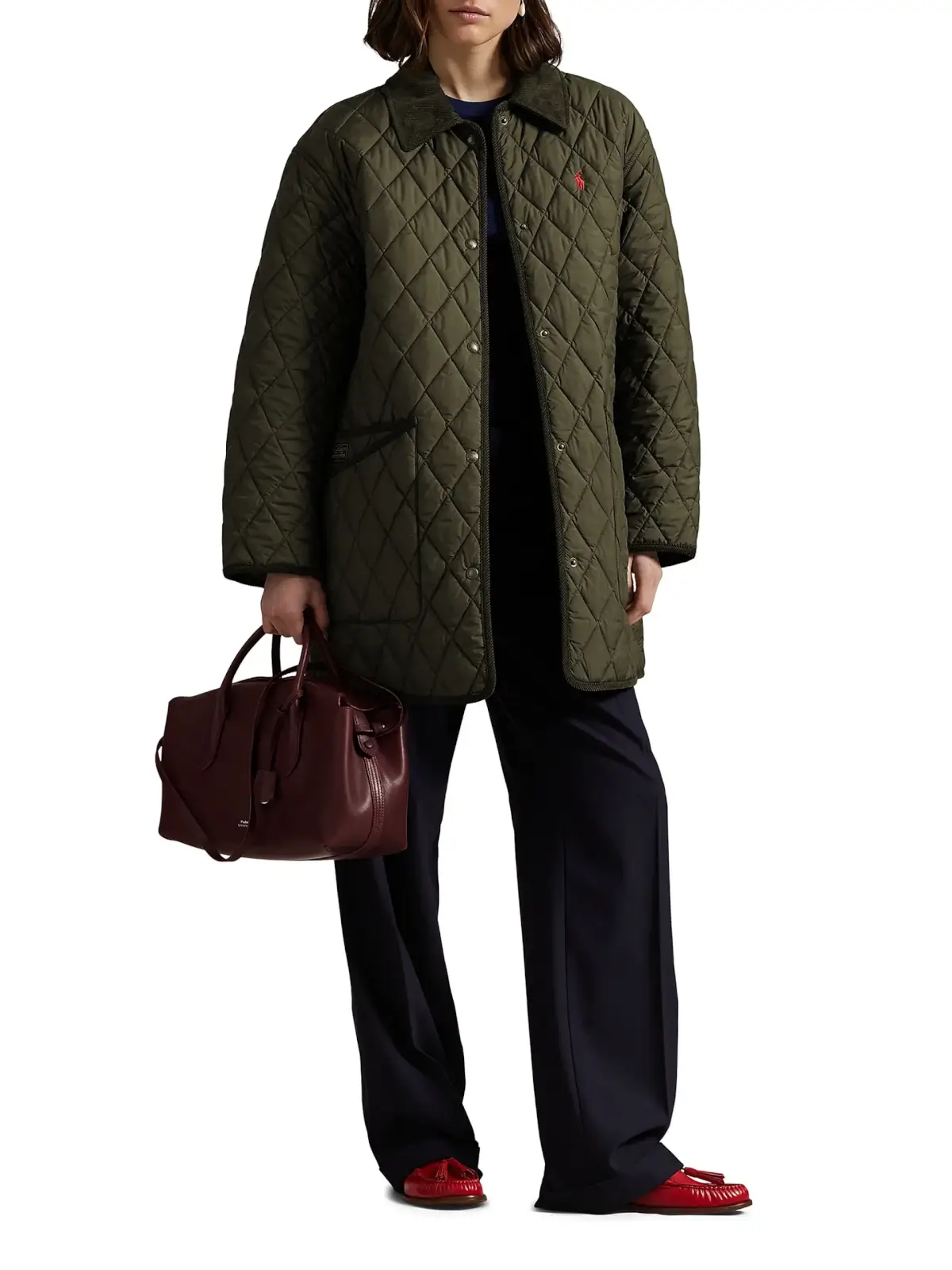 Fall 2025 Fashion: A Stylist's Lookbook of This Season's Trends - 70 A person wearing a quilted green jacket, dark pants, and red shoes holds a burgundy handbag against a plain background, showcasing effortless fall 2025 fashion.