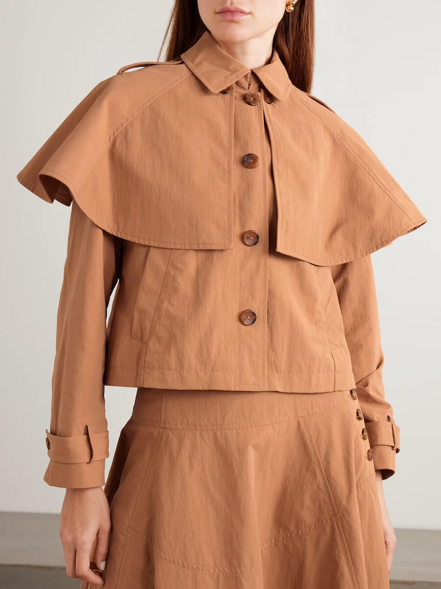 Fall 2025 Fashion: A Stylist's Lookbook of This Season's Trends - 73 A woman wearing a light brown button-up jacket with a cape detail over the shoulders and a matching skirt, embodying Fall 2025 fashion trends.