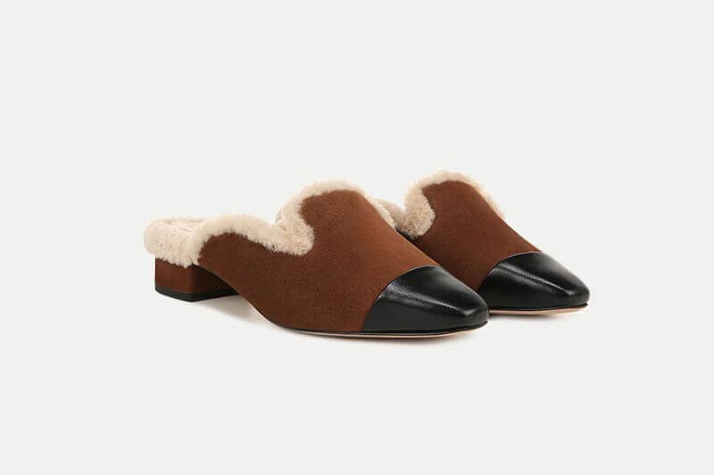 Fall 2025 Fashion: A Stylist's Lookbook of This Season's Trends - 22 A pair of brown slip-on mules with black rounded toe caps, low heels, and cream-colored shearling lining—perfect for cozy yet chic fall 2025 fashion.