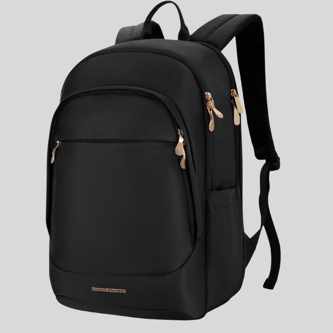 A black backpack with multiple zippered compartments and gold zipper pulls, featured on the SB Hot List for August 2025, shown against a plain gray background.