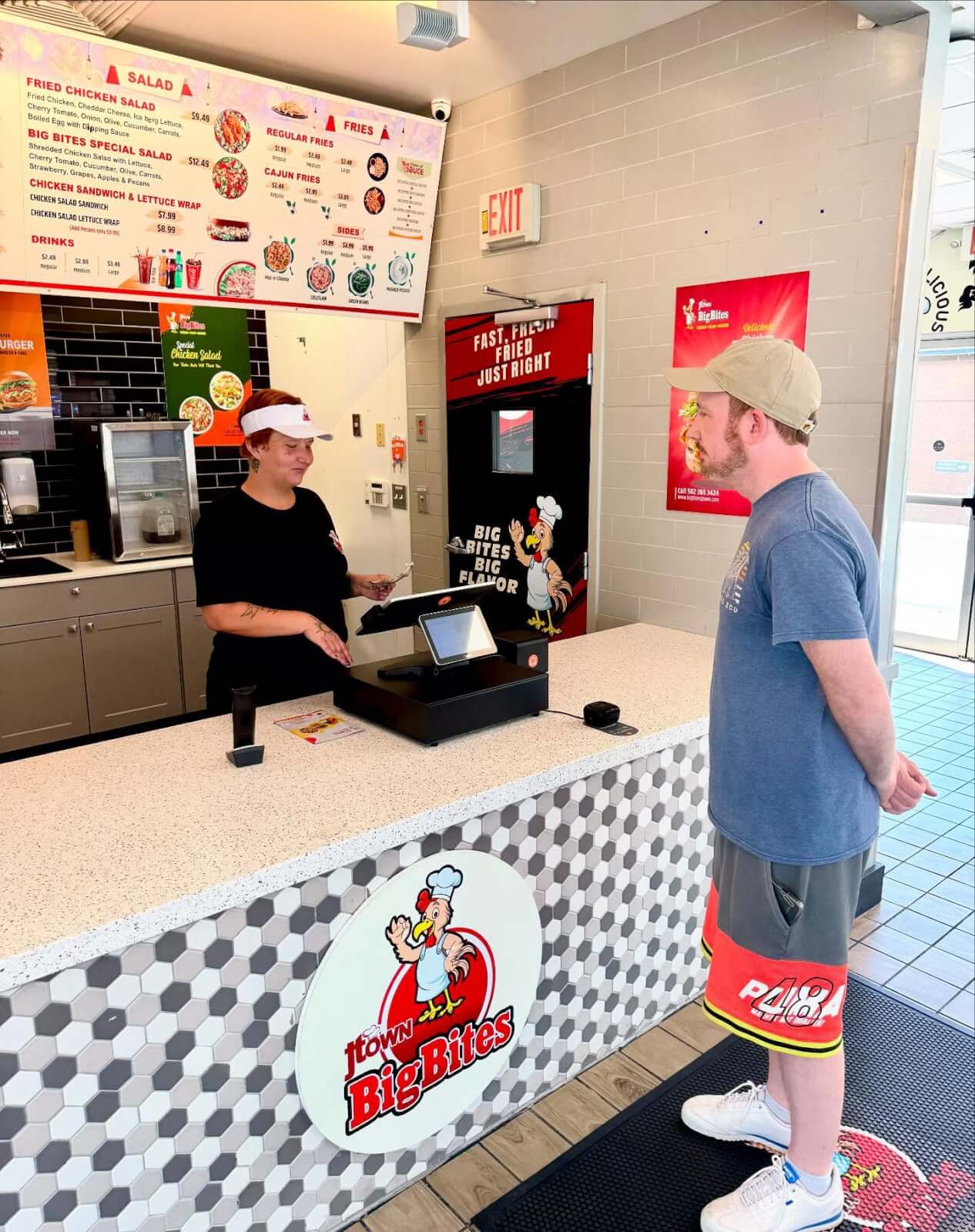 A man stands at the counter while a staff member prepares to take his order in Town Big Bites, one of the popular new restaurants among Louisville restaurants.